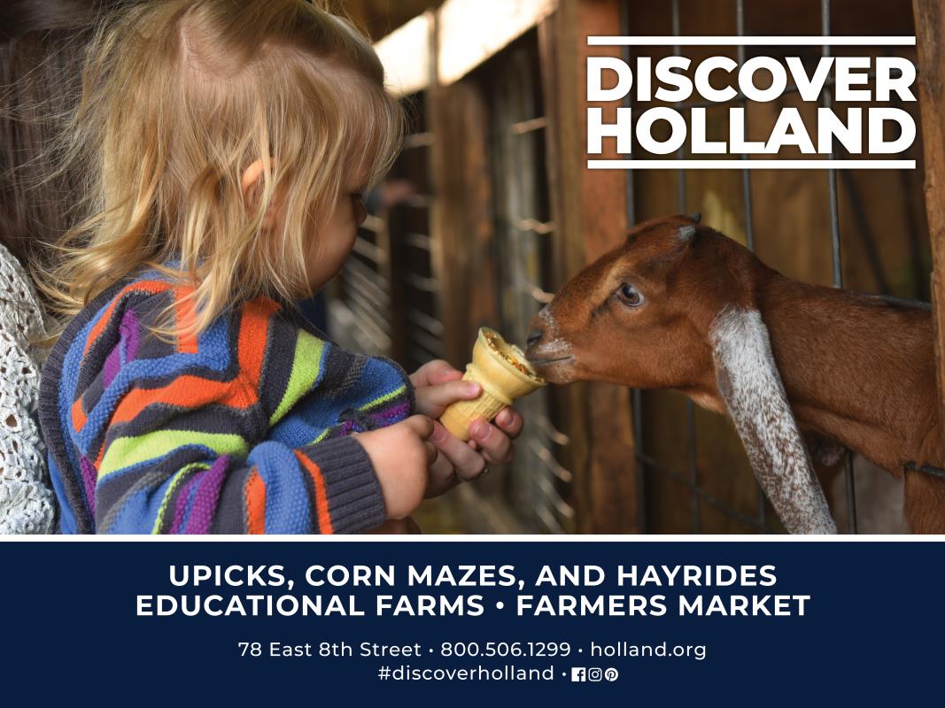 Girl feeding goat at petting farm in Holland, Michigan