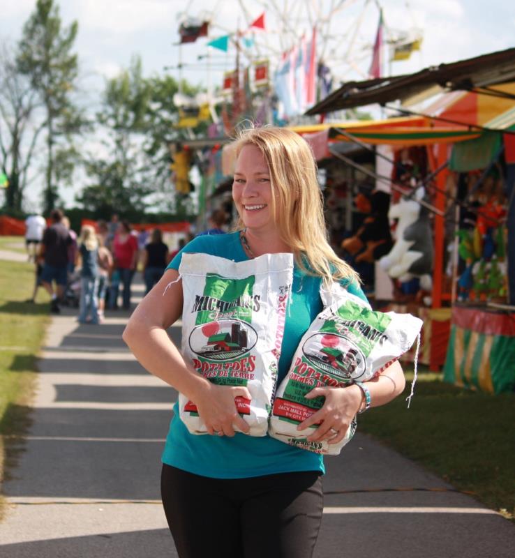 Woman holding.bags of patoates at the munger Potato Festival, Michigan