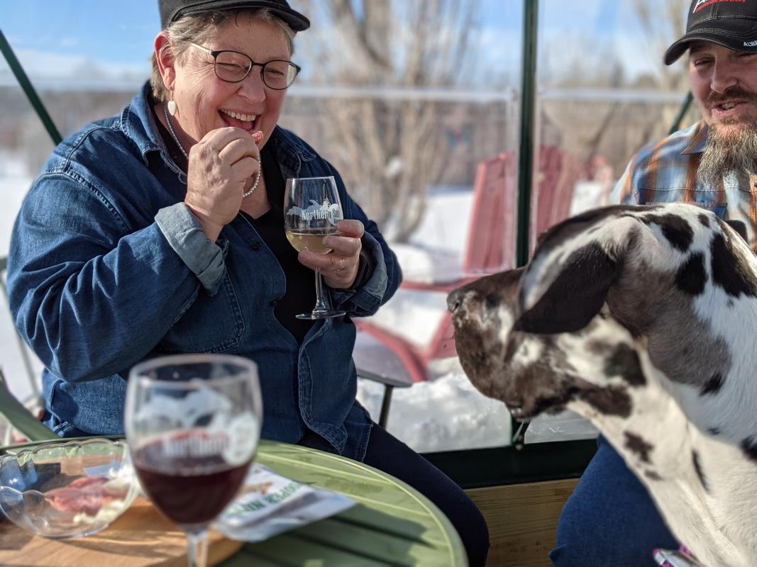Woman wine tasting with her dog