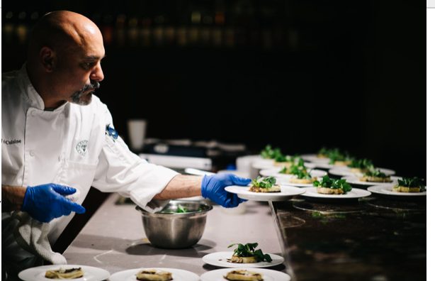 Chef serving food at wine dinner event