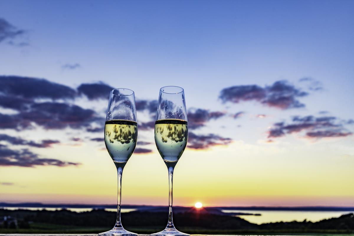 Two wine glasses, sunset in background