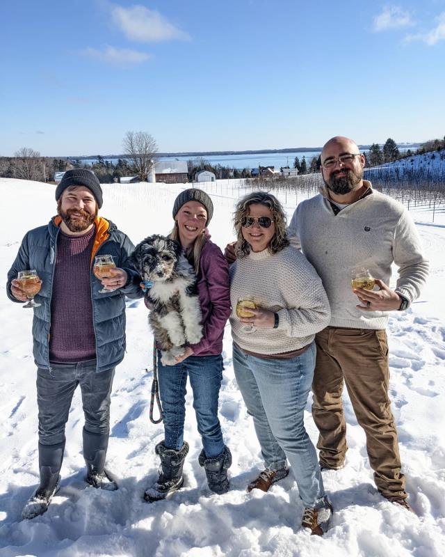 People snowshoeing and enjoying hard cider in the winter on a sunny day